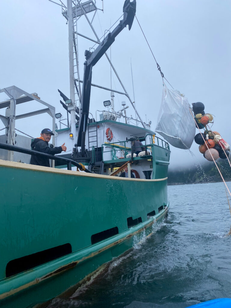 boat pulling trash out of ocean