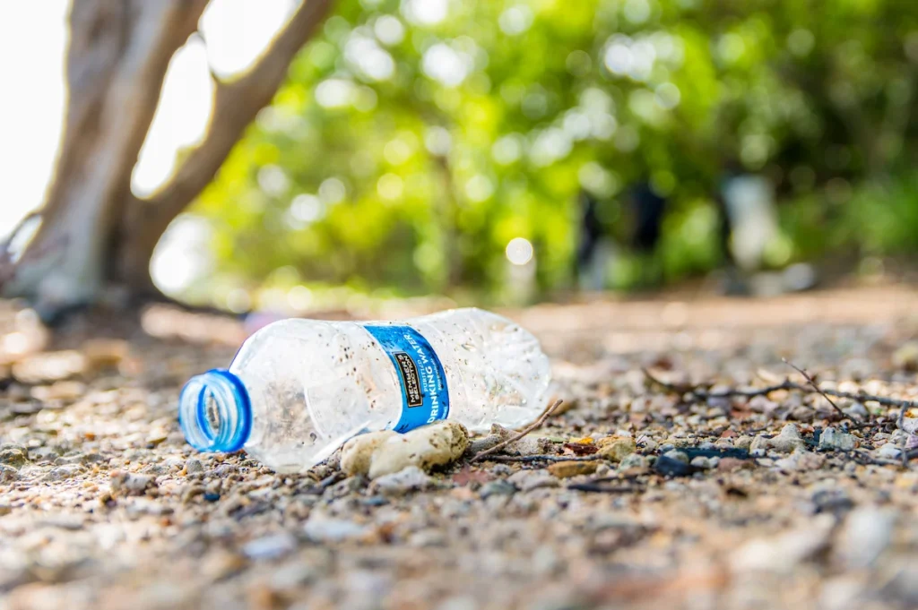 Plastic water bottle sits on the sand