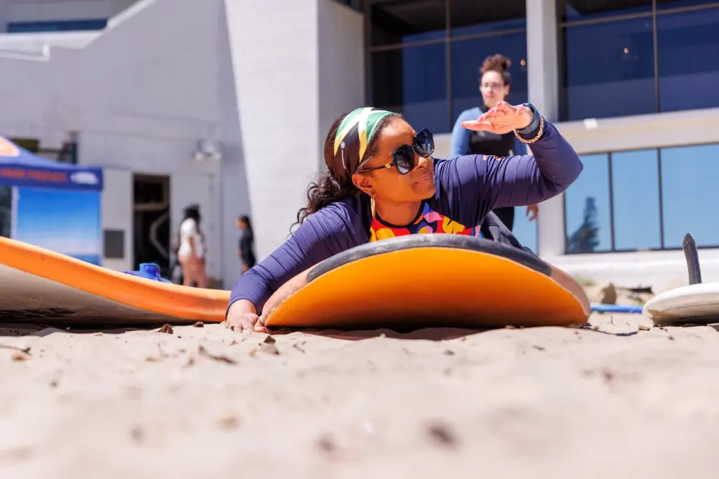 Woman practices surfing on the beach